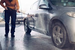 motorista joga jato de agua em carro ensaboado