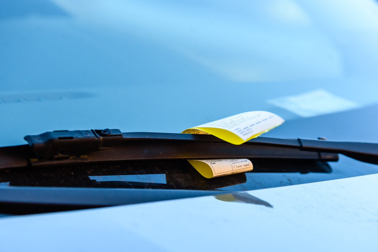 ticket de multa zona azul estacionamento rotativo no painel do carro preso pelo retrovisor