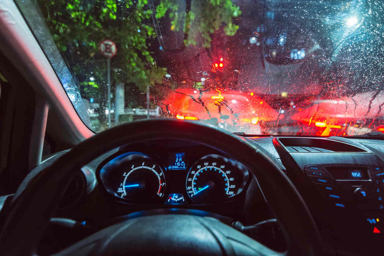 foto interna do ponto de vista do motorista no transito em dia de chuva