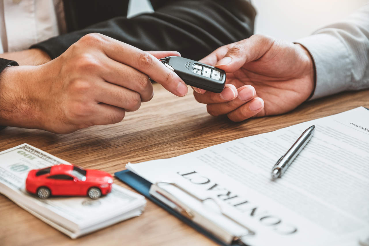 mão masculina segura chave de veículo após assinar contrato de aluguel de carro